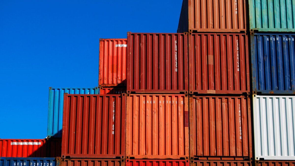 Stacked shipping containers against a bright blue sky